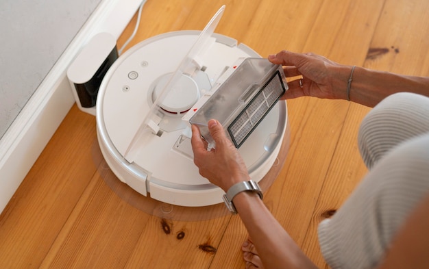 Photo gratuite femme à la maison avec un aspirateur robot sans fil