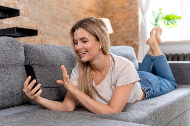 Femme à la maison ayant un appel vidéo avec la famille