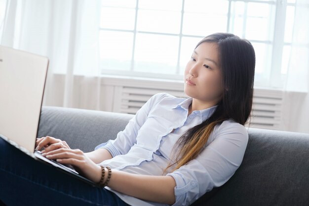 Femme à la maison avec ordinateur portable