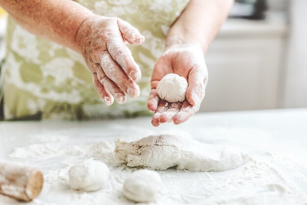 Femme à la maison, pétrir la pâte pour cuire des pâtes à pizza ou du pain. Concept de cuisine maison. Mode de vie