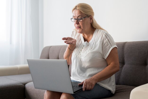 Femme à la maison en quarantaine ayant un appel vidéo avec des amis