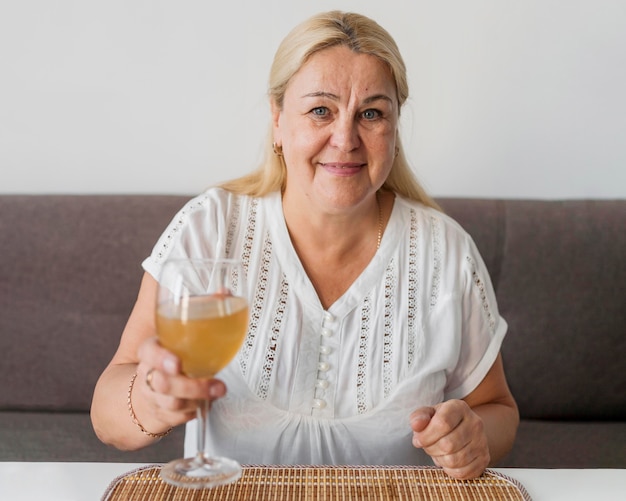 Femme à la maison en quarantaine en train de boire un verre