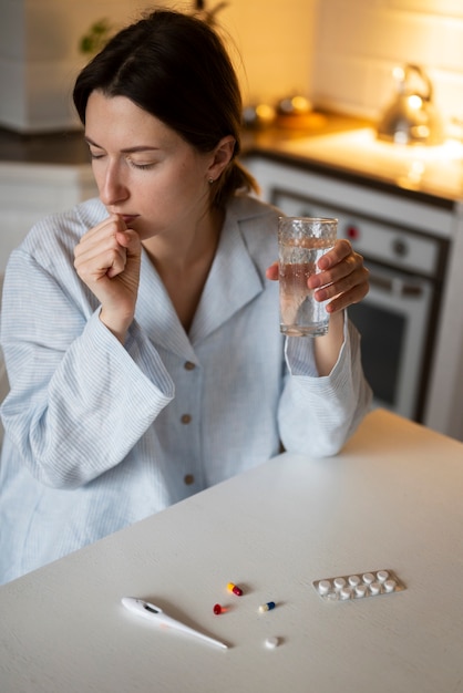 Femme malade de coup moyen avec la médecine