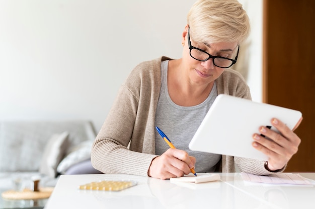 Femme malade de coup moyen avec tablette