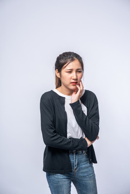 Une femme malade avec un mal de dents et une main tenant sur la joue