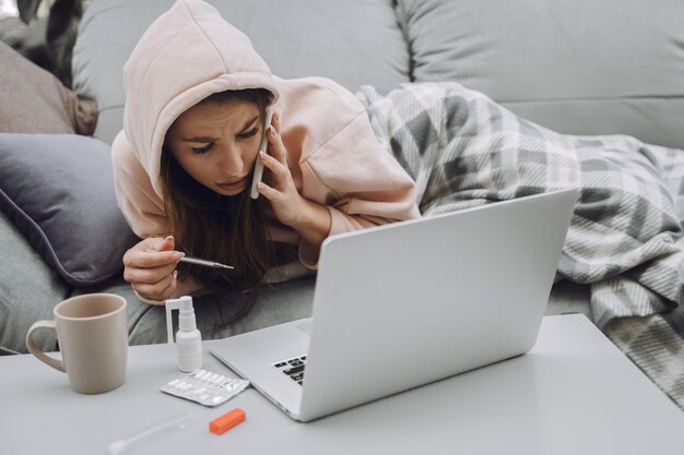 Femme malade avec maux de tête assis à la maison