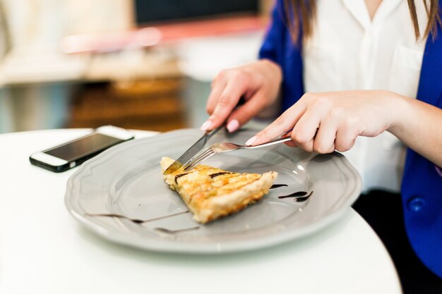 Une femme mange un gâteau au café