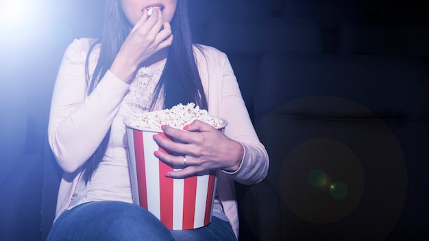 Femme mangeant du pop-corn au cinéma