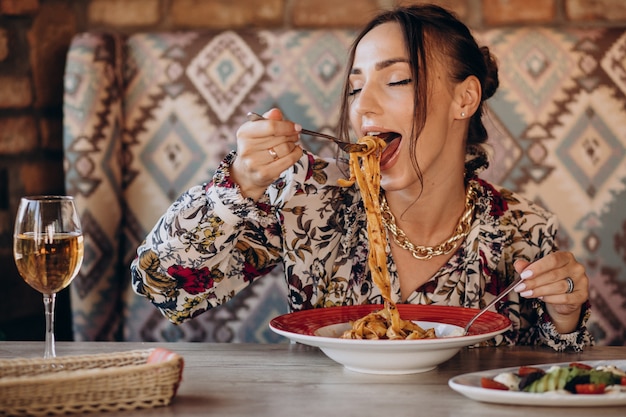 Femme mangeant des pâtes dans un restaurant italien