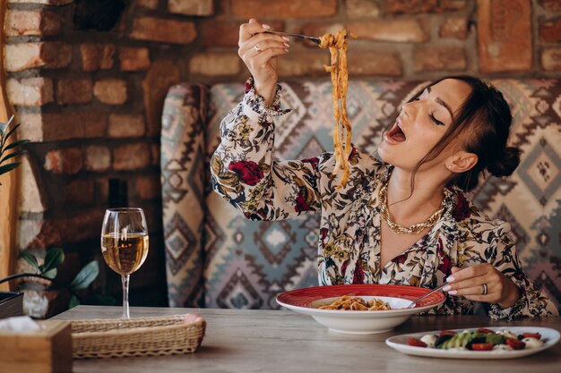 Femme mangeant des pâtes dans un restaurant italien