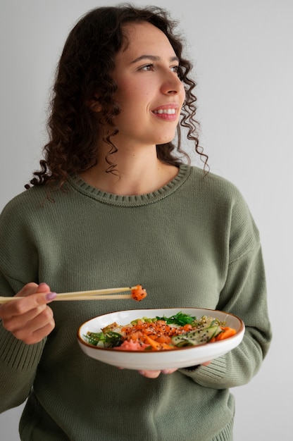 Photo gratuite femme mangeant un plat de fruits de mer au saumon