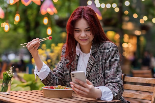 Photo gratuite une femme mangeant un poke dans un parc