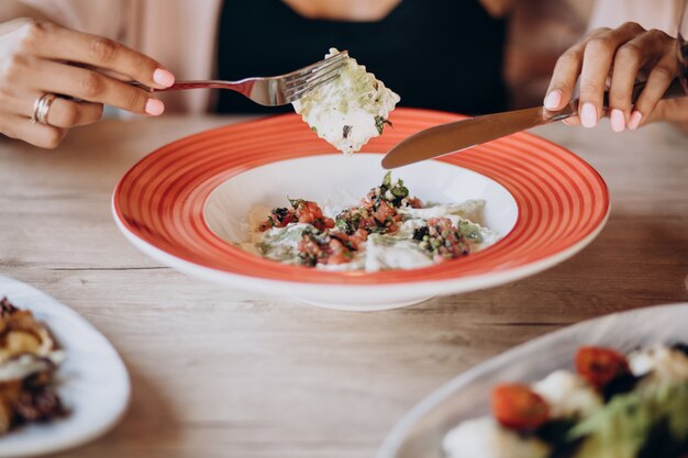 Femme mangeant des raviolis dans un restaurant italien