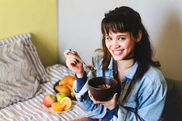 Femme, manger, céréale, sourire