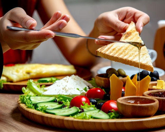 Femme, manger, miel, toast, petit déjeuner