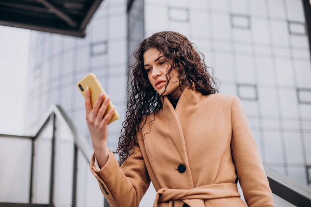 Femme en manteau beige marchant dans la ville