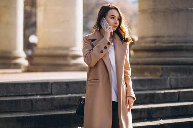 Femme en manteau parlant au téléphone