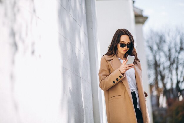 Femme en manteau parlant au téléphone