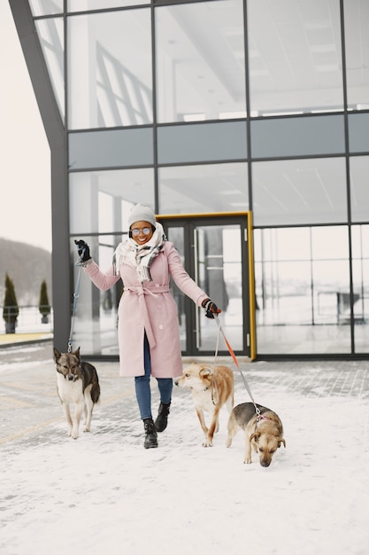 Femme en manteau rose, promener des chiens