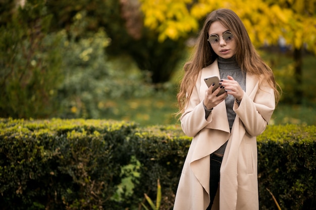 Femme en manteau avec un téléphone