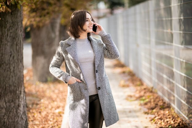 Femme en manteau avec un téléphone