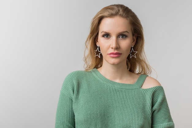 femme avec maquillage élégant et pull vert posant sur rose