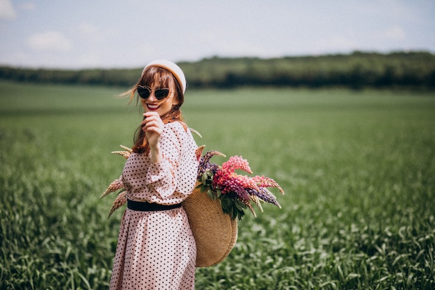 Femme marchant dans un champ avec des lupinus