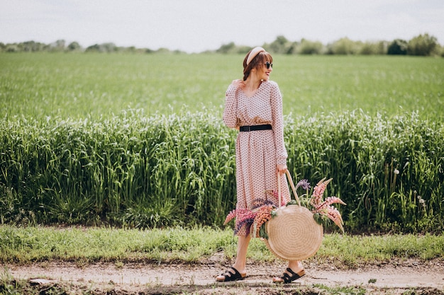 Femme marchant dans un champ avec des lupinus