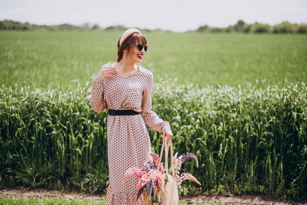 Femme marchant dans un champ avec des lupinus