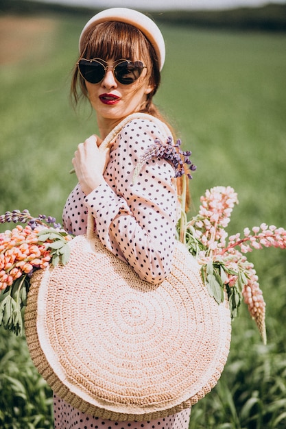 Femme marchant dans un champ avec des lupinus