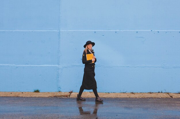 Femme marchant devant le mur bleu