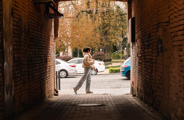 Photo gratuite une femme marche le long d'une rue de la ville une vue de l'allée un passant occasionnel