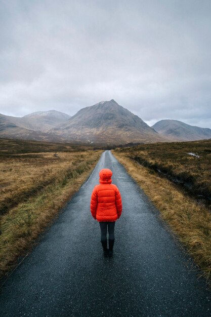 Femme marche sur une route à Glen Etive, Ecosse