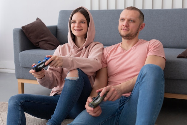 Photo gratuite femme et mari jouant à des jeux vidéo ensemble à la maison