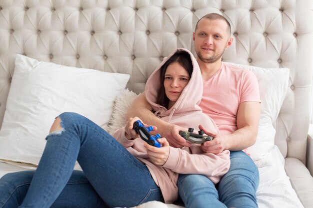 Femme et mari jouant à des jeux vidéo à la maison