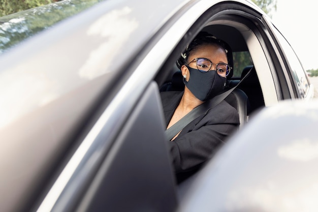 Femme Avec Masque Facial Regardant Dans Le Miroir Tout En Conduisant Sa Voiture