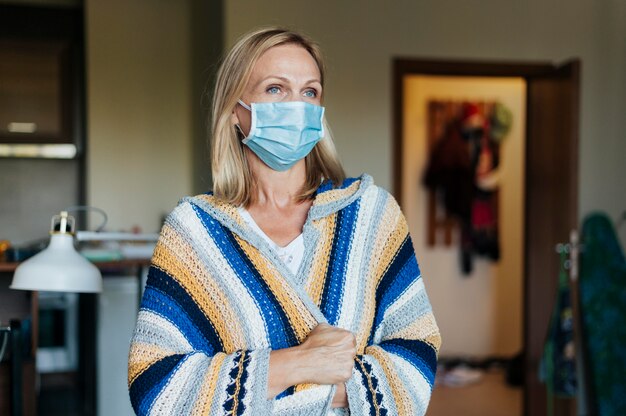 Femme avec masque médical en quarantaine à la maison