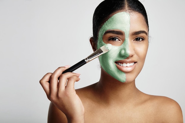 Femme avec un masque vert frais à l'avocat