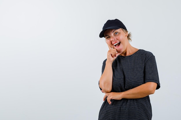 Femme mature blonde dans un t-shirt noir et une casquette noire