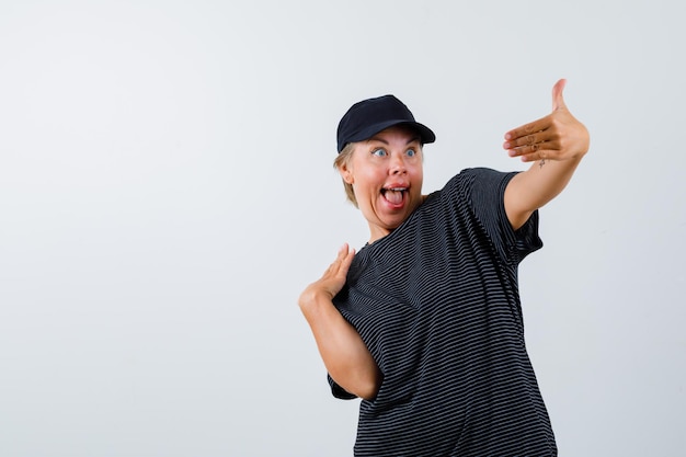 Femme Mature Blonde Dans Un T-shirt Noir Et Une Casquette Noire