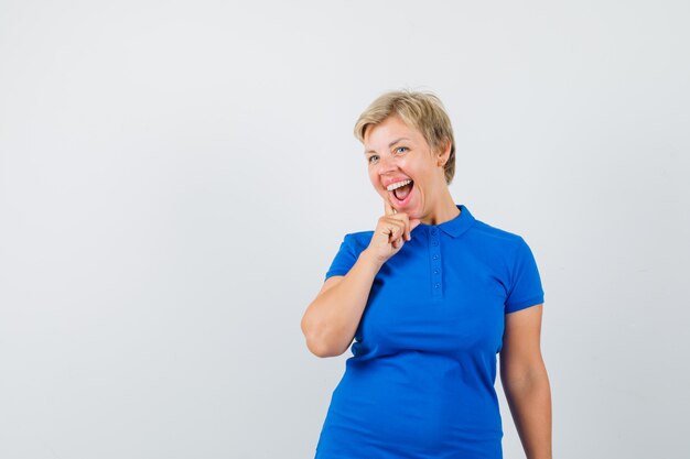 Femme mature debout dans la pensée pose en t-shirt et à la recherche de plaisir