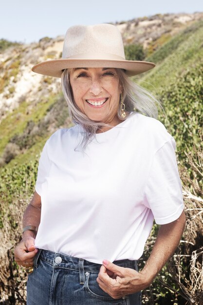 Femme mature en t-shirt blanc et chapeau de panama pour un tournage en plein air d'été