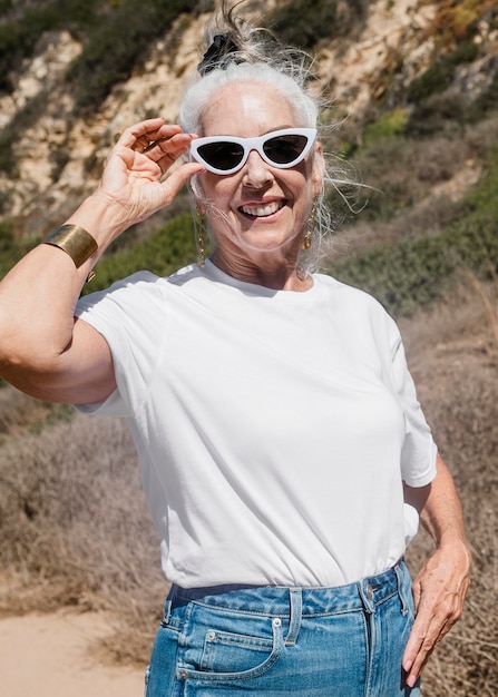 Femme mature en tee blanc pour un tournage en plein air d'été