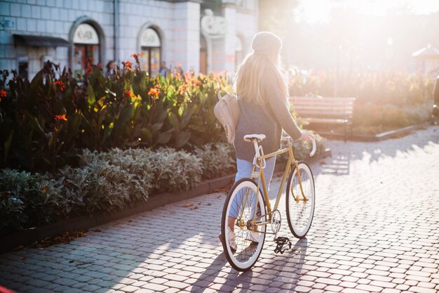 Femme méconnaissable, marchant à vélo dans le parc
