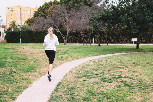 Femme méconnaissable qui court dans le parc