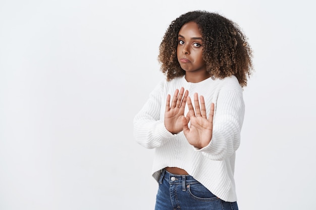 Photo gratuite une femme mécontente et déçue intense ne veut pas participer à une action suspecte en tirant les mains vers la caméra dans un geste d'arrêt et de refus pinçant les lèvres en signe d'aversion, rejetant l'offre