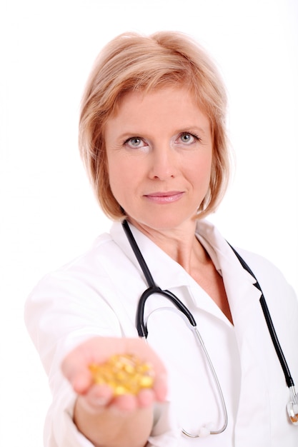 Femme médecin adulte avec des pilules à la main sur fond blanc