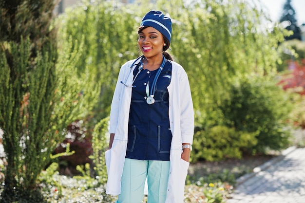 Femme médecin afro-américaine avec stéthoscope posé en plein air