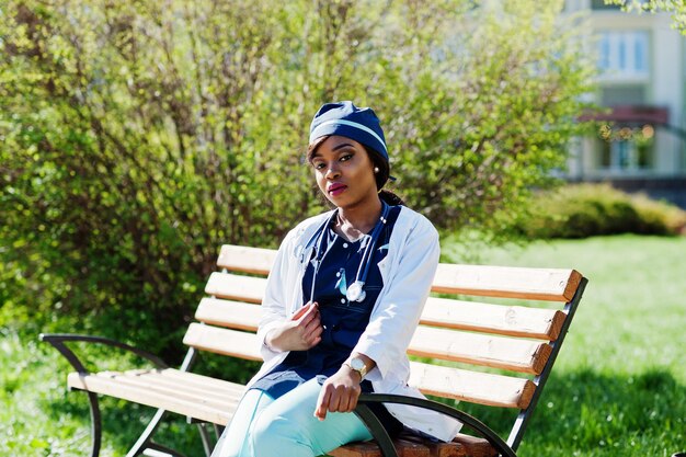 Femme médecin afro-américaine avec stéthoscope posé en plein air