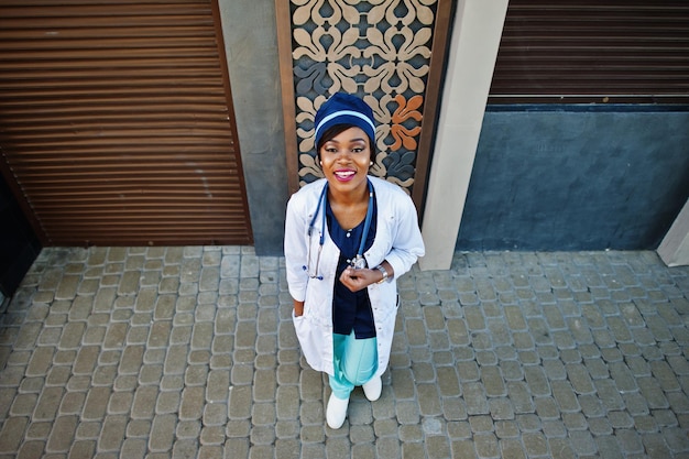 Femme médecin afro-américaine avec stéthoscope posé en plein air
